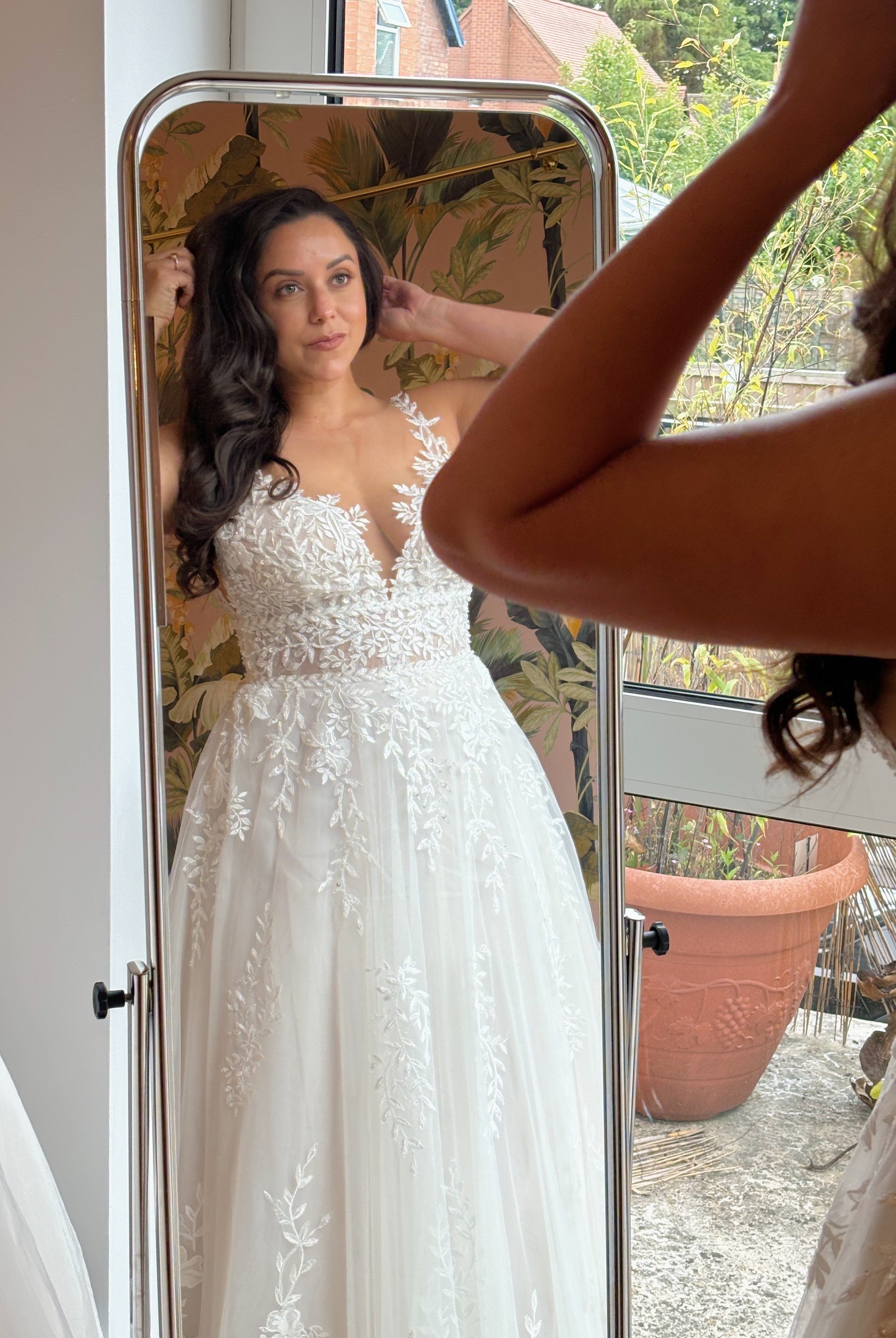 bride looking in the mirror wearing a wedding dress