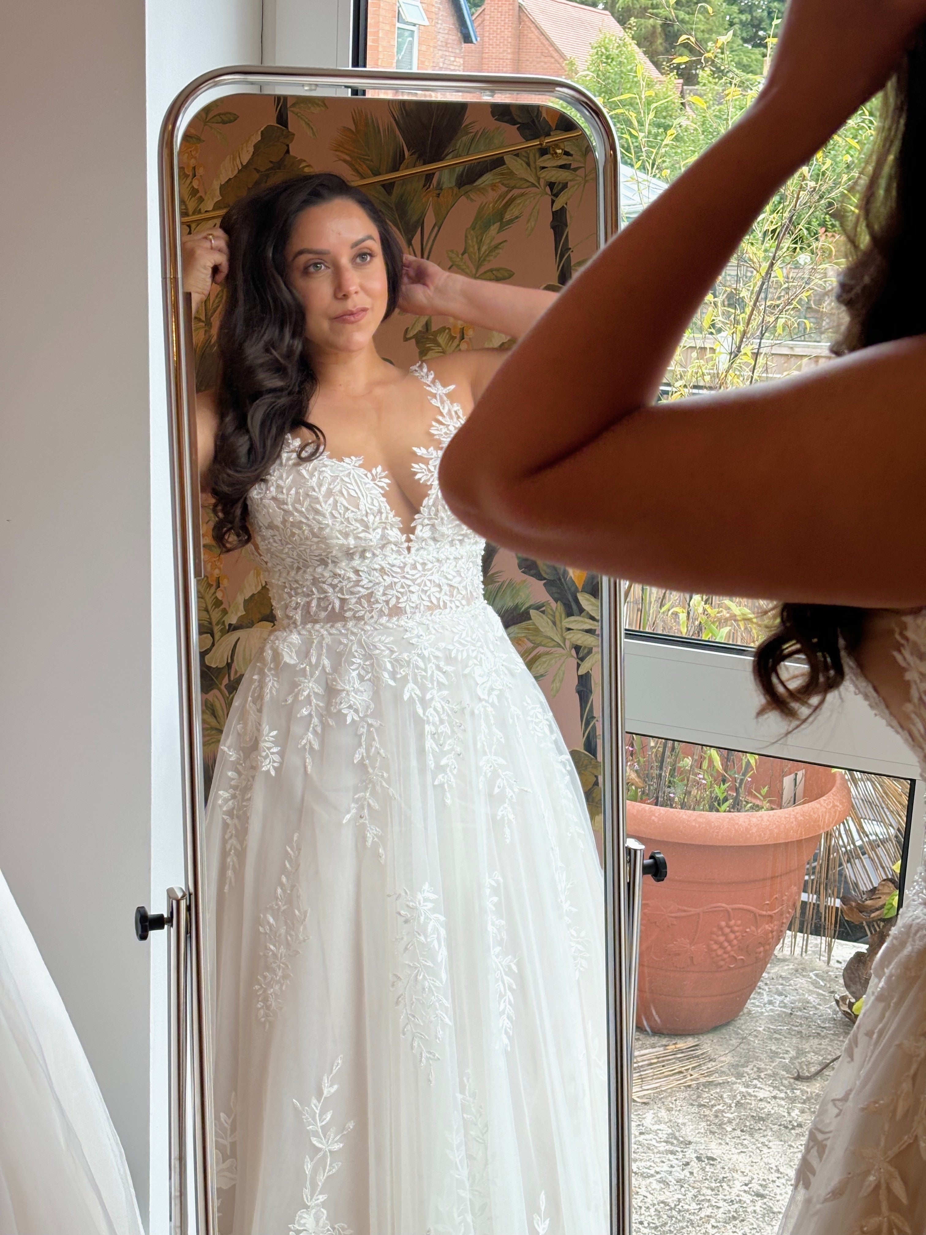 bride looking in the mirror wearing a wedding dress